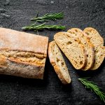 Sliced,Ciabatta,Bread,With,Rosemary.,On,Black,Rustic,Background
