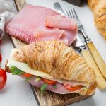 Classic BLT croissant sandwiches set, with herbs and ingredients, on white stone background