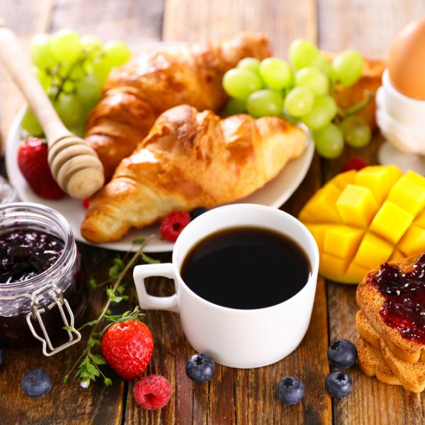 continental breakfast with coffee cup, fruit and croissant