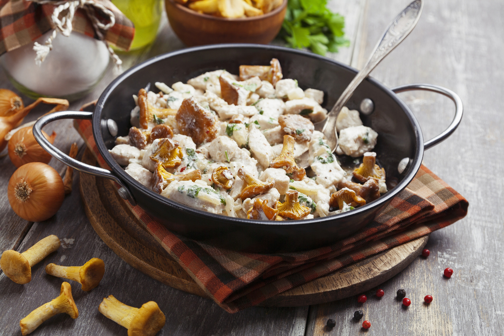 Chicken fillet with chanterelles and cream in a pan on the table